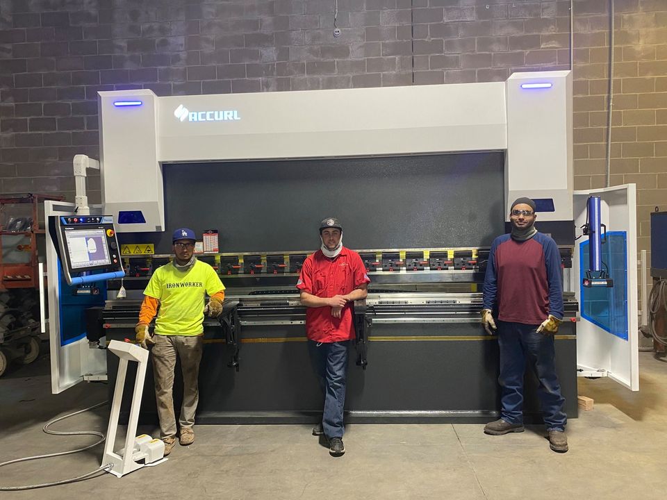 A full shot of three workers in front of the Accerlusa Master Cut Sheat.