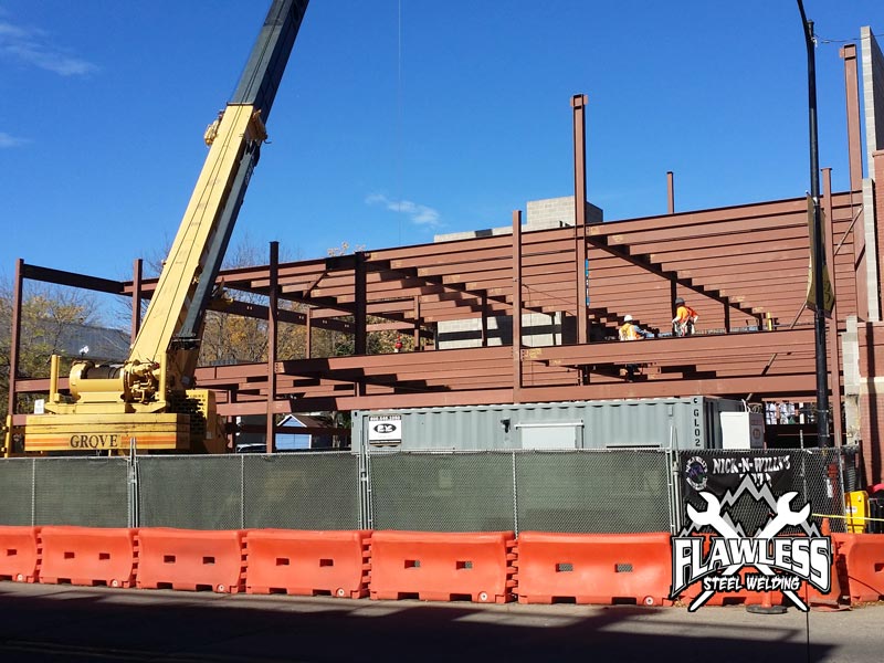 Crane truck and steel structure in an ongoing Boulder office and retail construction project.
