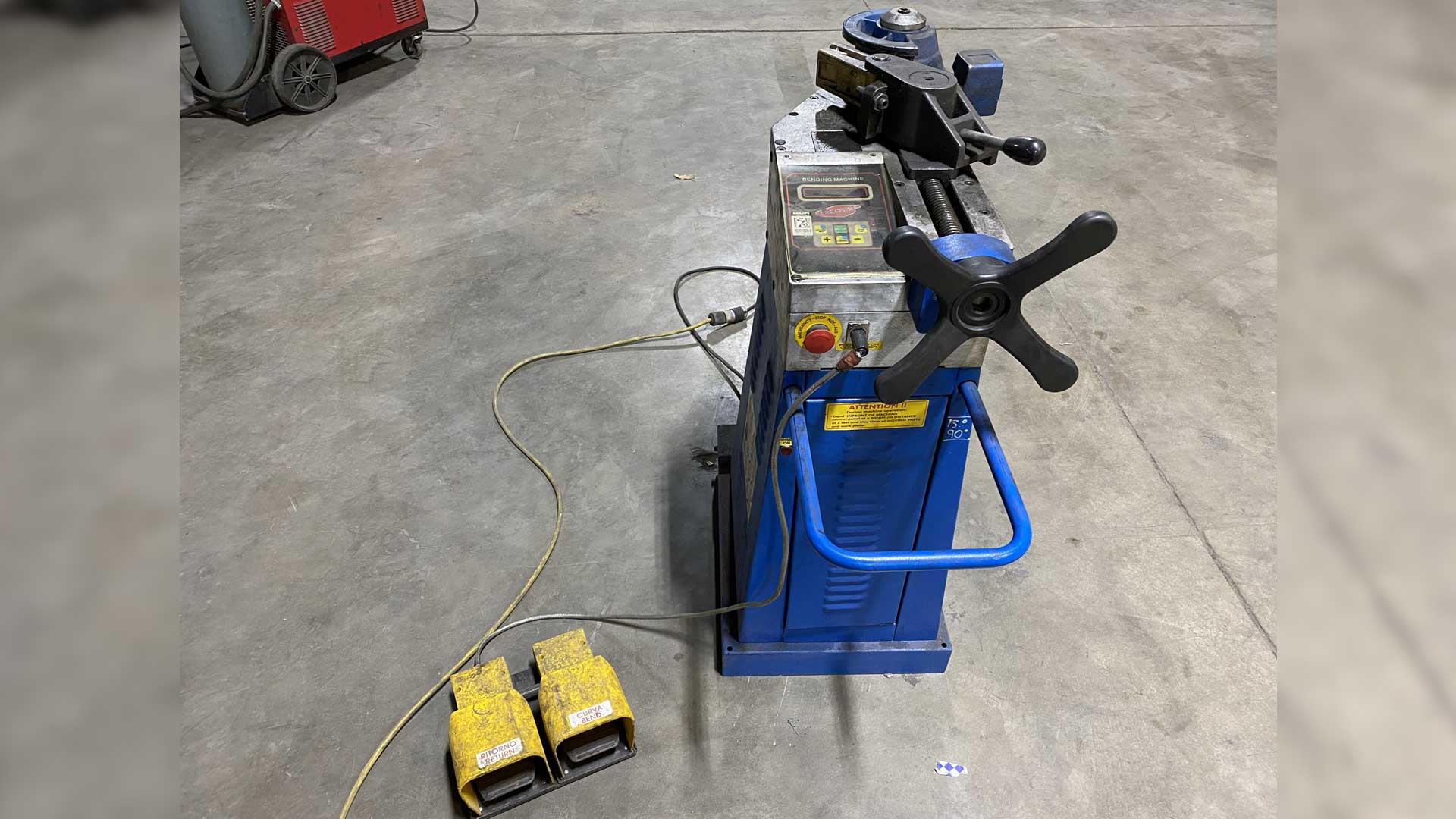A blue Ercoline pipe bender was placed on the floor.