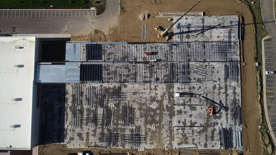 Aerial shot of an ongoing construction site with cranes and other heavy equipment inside.