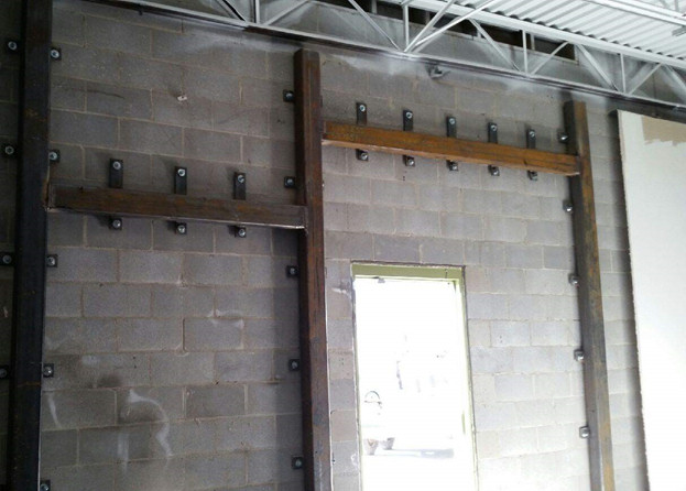 A concrete wall with steel braces.